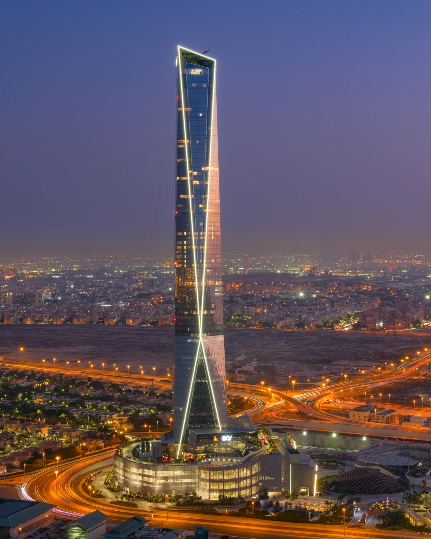 High-rise tower photographed at dusk with corrected verticals and warm interior light