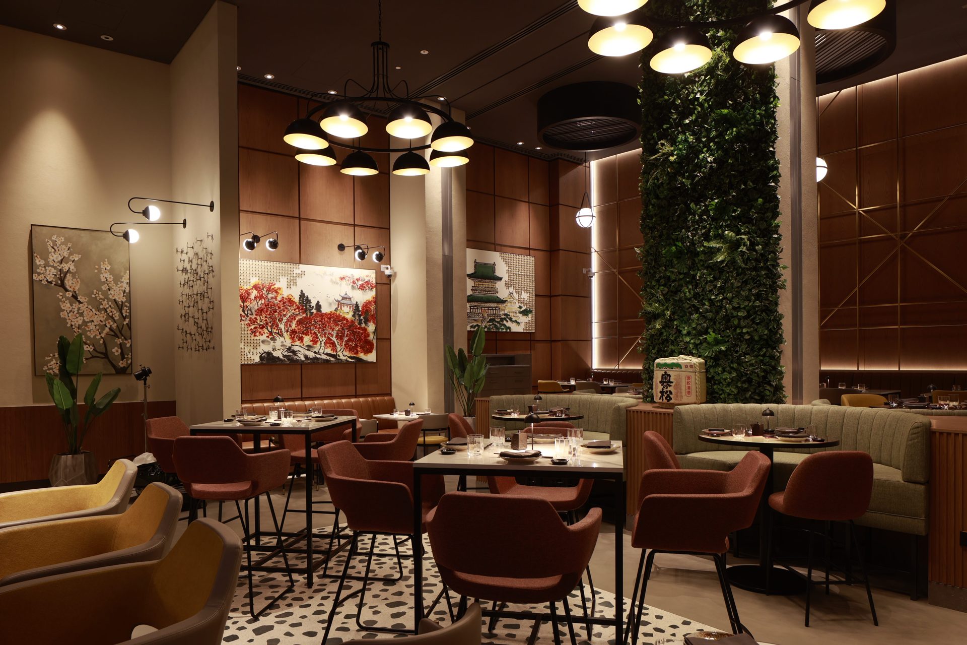 Yoru Japanese restaurant at Rotana Ras Al Khaimah before the refresh — heavy orange cast and crushed shadows across the timber panelling and dining seating