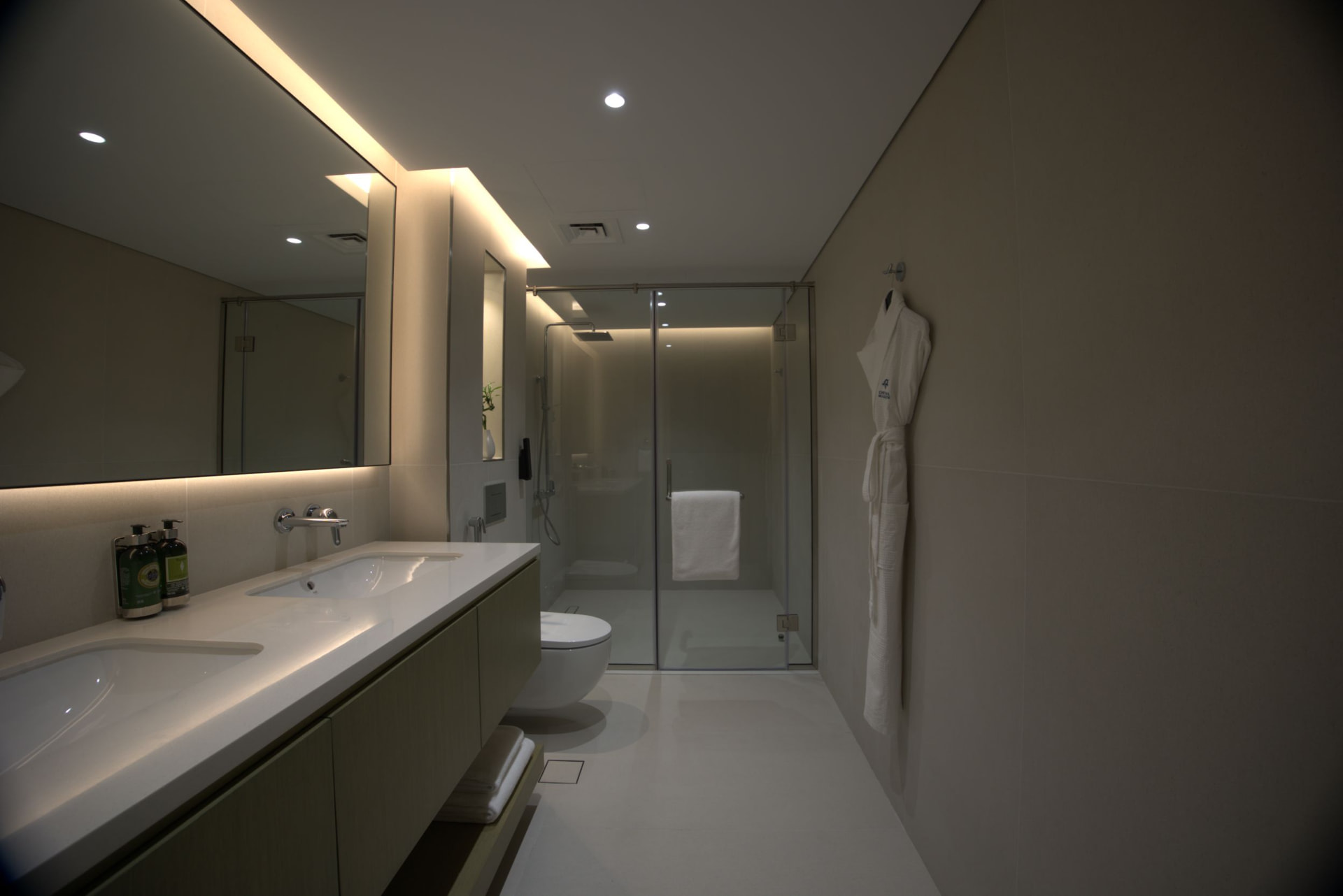 Cheval Maison The Palm master bathroom before the photography refresh — dim, muddy exposure with grey-green colour cast across the twin vanity and walk-in shower