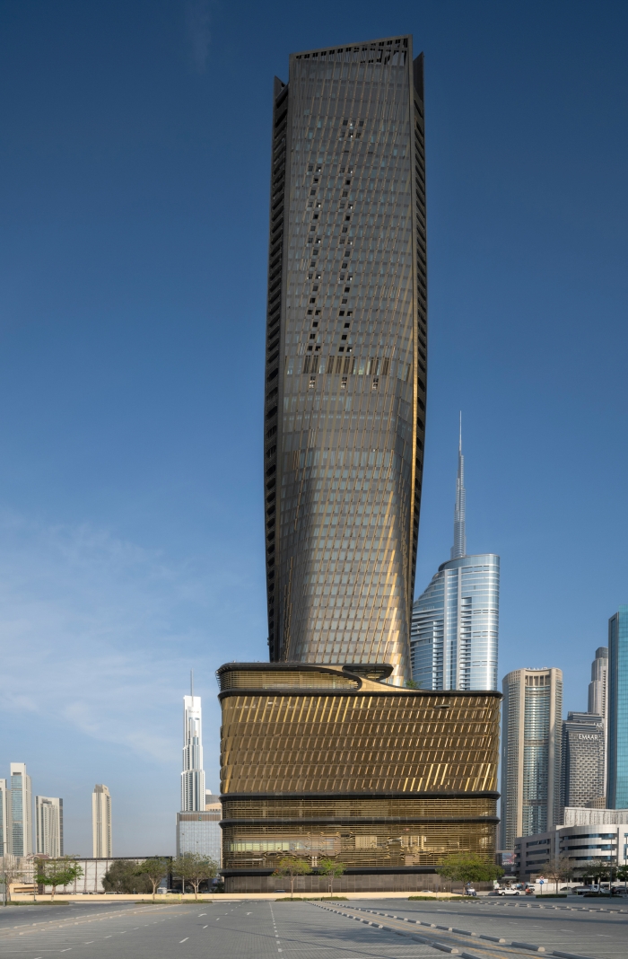 Wasl Tower, Dubai — low-angle base view with Burj Khalifa on the skyline